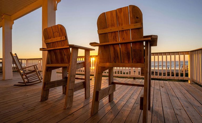 Terrasse en bois avec deux chaises devant un coucher de soleil